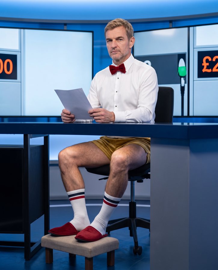 Under the desk: shorts, sports socks and red slippers